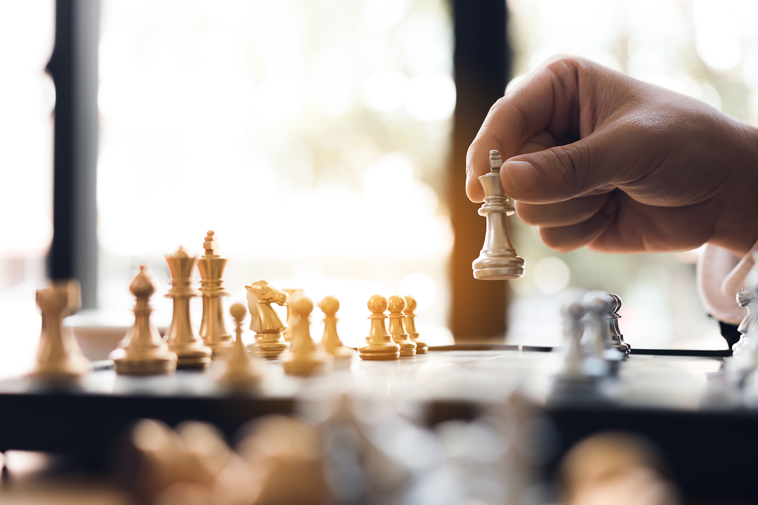 close up businessman hand moving the king in a chess game for w